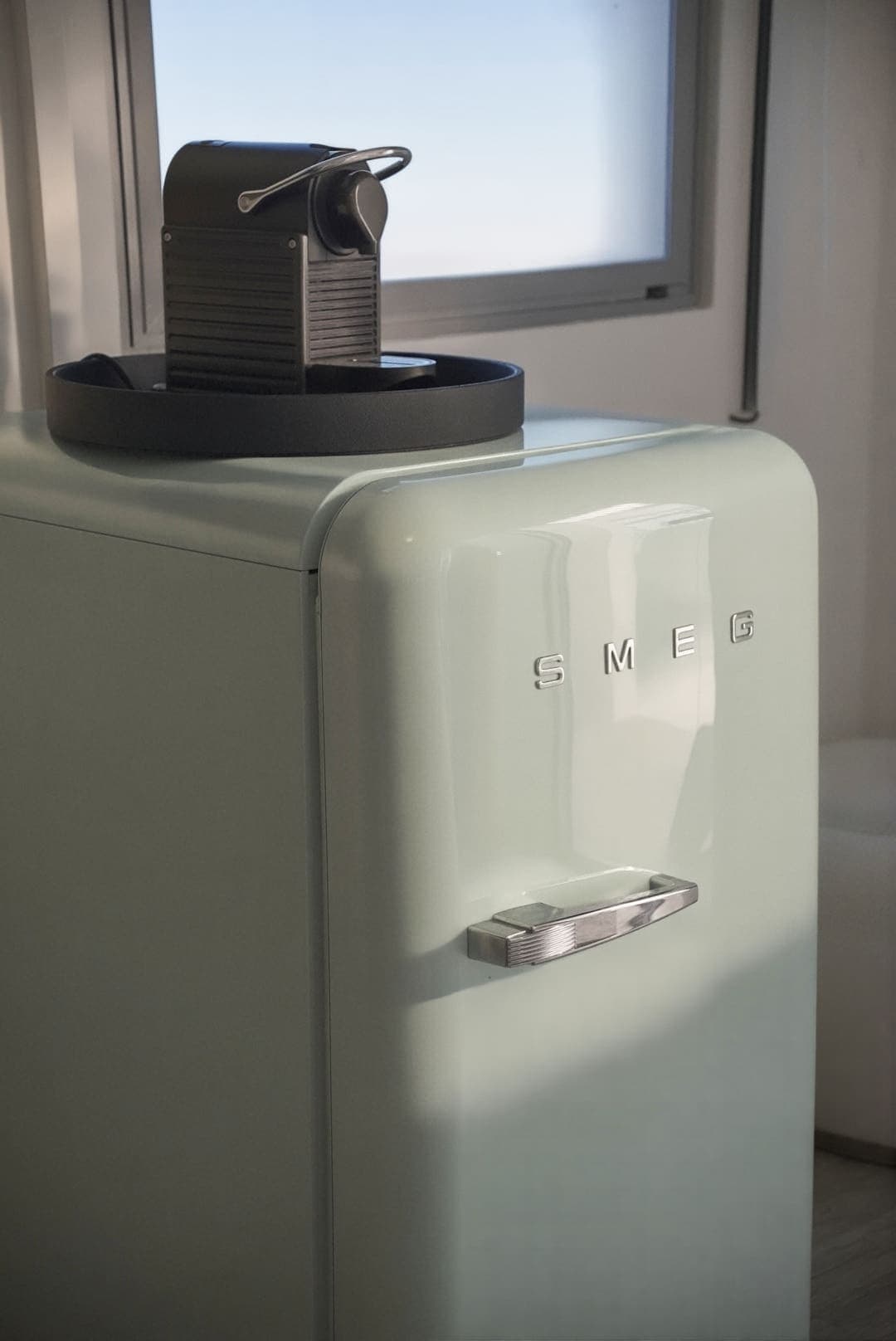 Nevera retro verde agua con una cafetera encima